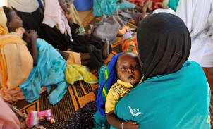 A woman holds her 6-month-old son, Abdul Rachman Salim, who is suffering from diarrhea and an eye infection, outside the Mercy Malaysia clinic in Zam Zam camp, in North Darfur. Aid agencies provide crucial services to 2.5 million displaced people in the region. Lynsey Addario/Los Angeles Times