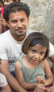 Ilyas Masih with one of his seven daughters. Feeding so many is not easy. "I struggle even to buy a single kilo of `atta’ [wheat flour], which costs Rs 30 [36 US cents], and even that produces just about half a `roti’ [flat bread] for each of us,” he said. For Ilyas’s family, securing each meal - eaten on the floor around a kerosene oil stove on which Nasim cooks - is an ordeal. “Especially at night, it is painful to hear the children beg for more food. Sometimes they snatch food from each other,” Ilyas said. Photo: Kamila Hyat/IRIN 