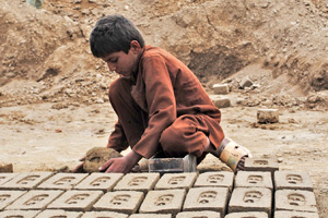 Photo of a child working in an Afgan brick kiln. Bonded labor in Afghanistan’s brick kilns is one of the most common forms of hazardous labor in the country. More than half of the brick kiln workers surveyed in a recent report by the International Labor Organization (ILO) were children. According to the ILO, the kilns rely on debt bondage: Workers and their families are tied to a kiln by the need to pay off loans taken out for basic necessities, medical expenses, weddings and funerals. Photo: IRIN