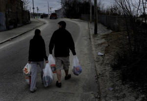 Photo of man and wife waling home with bags of groceries. Rhode Island town relies on food stamps: In Woonsocket, R.I., a third of the residents use SNAP, formerly known as food stamps, to pay for groceries. That means the businesses in the struggling town also rely on the program to survive. Photo: Michael S. Williamson/Washington Post