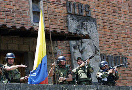 Gen. Mario Montoya, left, helps raise the flag in Medellin in 2002. A former paramilitary fighter accuses Montoya of collaborating with death squads that took control of the city's poor neighborhoods from guerrillas a few years ago. Photo: Fernando Vergara/Agence France-presse/Getty Images) 