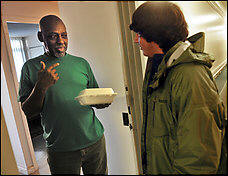 William Kittrell, 62, receives a meal from Chris DeSouza, 17, through the Campus Kitchen program at the District's Gonzaga College High School. (By Bill O'leary -- The Washington Post) 
