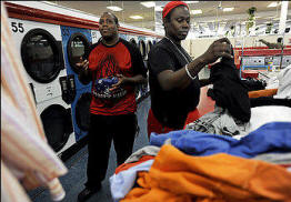 Time is money, and both are in short supply: Quintin Strange, left, and Kenneth Thomas say they've cut back their weekly laundering to every third week because of the recession. Photo: Lois Raimondo/Washington Post) 