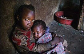 Seven-year-old Sinikiwe cradles her young brother Simba. Hunger stalks their family. Their local church, supported by the charity Tearfund provides what little food, clothing and seed they have. Photo: BBC