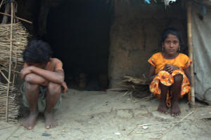 10-year-old Meena Devi, right, and her older brother Sunil, 11, outside their hut in Jhanwatola village, Bihar.