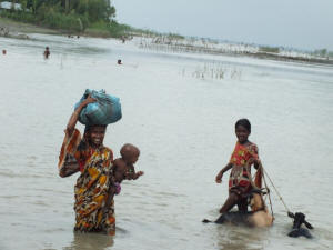 A mother and her children wading through floodwaters in Bangladesh. Photo: IRIN News