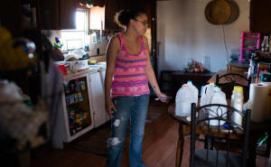 Tereza Sedgwick in the kitchen of her Bartlett, Ohio, home. Living in a borrowed house with no water, she uses tap water from jugs for brushing teeth and other chores.  Photo: Sarah L Vosin/Washington Post