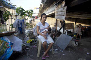 Rizelle, 17, and her three-week-old baby. Rizelle lives in a squatted home under a bridge in San Dionisio, Indonesia. Photo: Save the Children