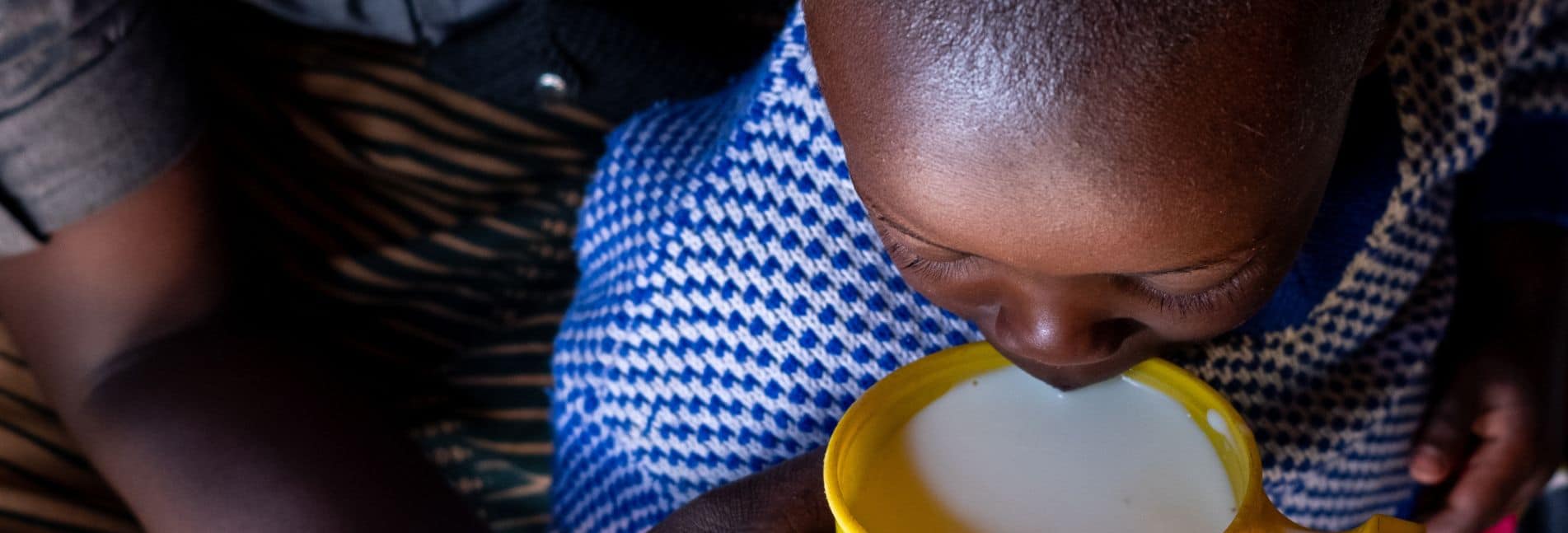 Child drinking milk in Rwanda.